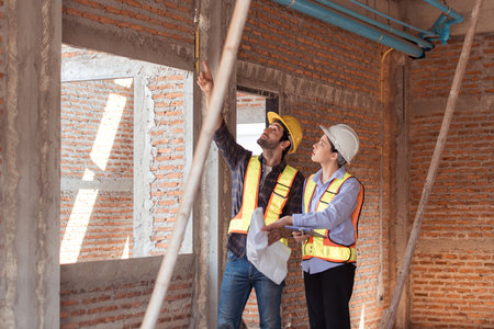 Architects and engineers work together to assess the residential home construction site's progressの写真素材