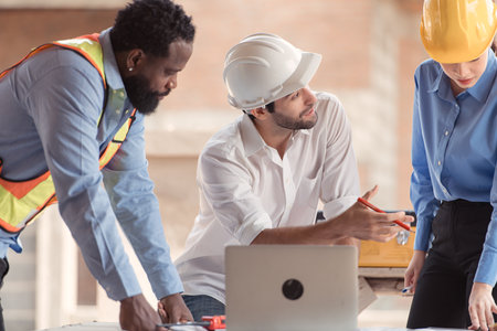 Group of architects and engineers work together to assess the residential home construction site's progressの写真素材