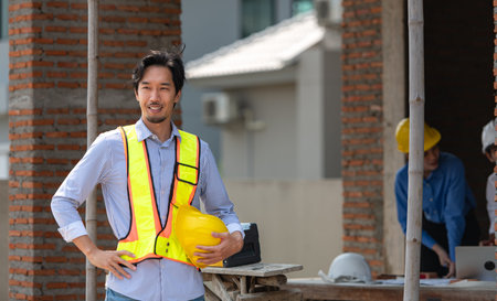 Portrait of engineers work together to assess the residential home construction site's progress