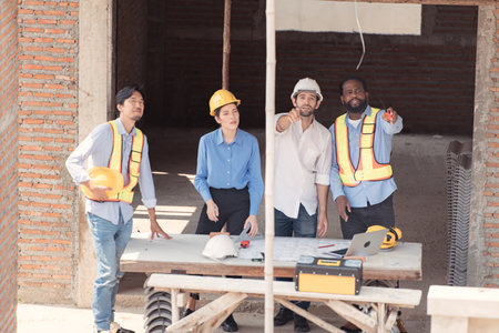 Group of architects and engineers work together to assess the residential home construction site's progressの写真素材