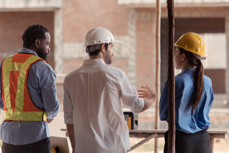 Group of architects and engineers work together to assess the residential home construction site's...