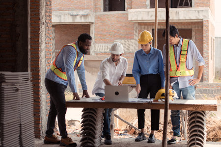 Group of architects and engineers work together to assess the residential home construction site's...