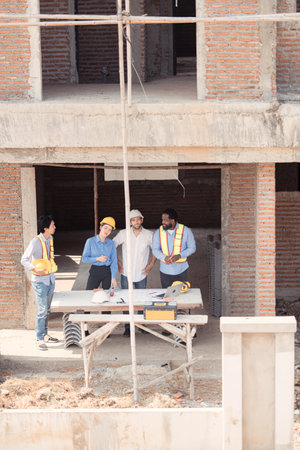 Group of architects and engineers work together to assess the residential home construction site's...