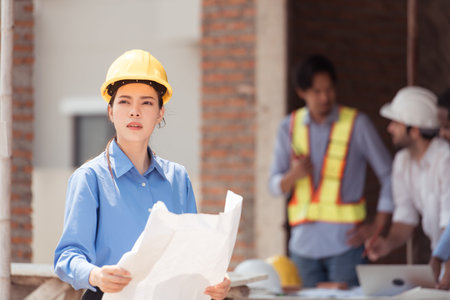Portrait of engineers work together to assess the residential home construction site's progress