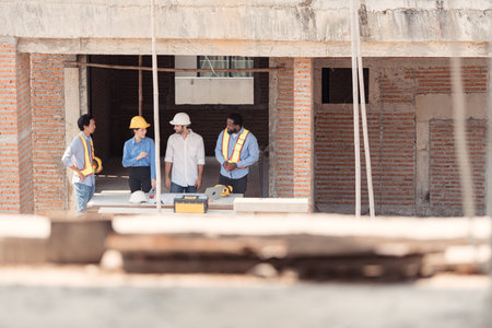 Group of architects and engineers work together to assess the residential home construction site's...