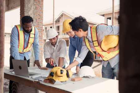 Group of architects and engineers work together to assess the residential home construction site's progressの写真素材