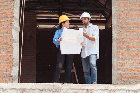 Architects and engineers work together to assess the residential home construction site's progressの写真素材