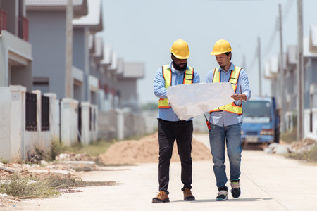 Architects and engineers work together to assess the residential home construction site's progressの写真素材