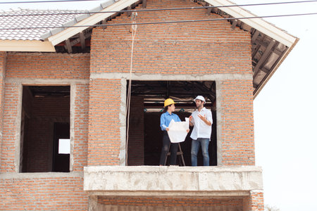 Architects and engineers work together to assess the residential home construction site's progressの写真素材