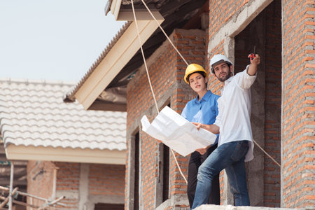 Architects and engineers work together to assess the residential home construction site's progressの写真素材