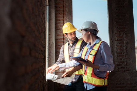 Architects and engineers work together to assess the residential home construction site's progressの写真素材
