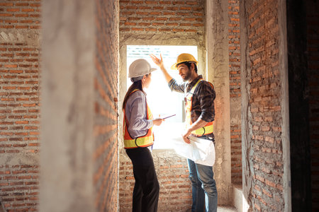 Architects and engineers work together to assess the residential home construction site's progressの写真素材