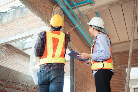 Architects and engineers work together to assess the residential home construction site's progress