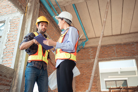 Architects and engineers work together to assess the residential home construction site's progress