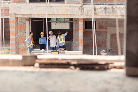 Group of architects and engineers work together to assess the residential home construction site's...