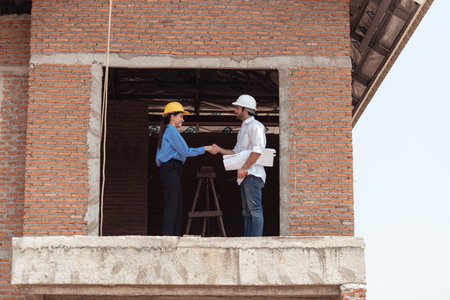 Architects and engineers work together to assess the residential home construction site's progressの写真素材