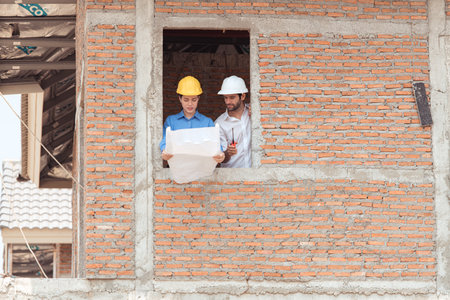 Architects and engineers work together to assess the residential home construction site's progressの写真素材