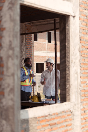 Architects and engineers work together to assess the residential home construction site's progressの写真素材