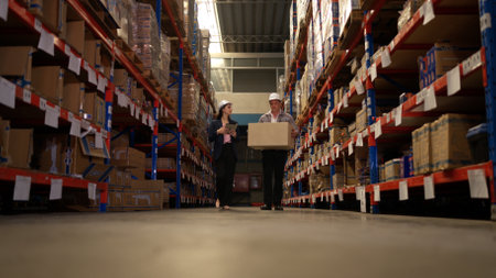 Business woman and warehouse workers are reviewing the list of items based on the documentationの写真素材