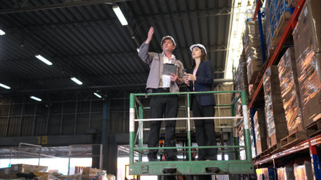 Business woman and warehouse workers are reviewing the list of items based on the documentationの写真素材
