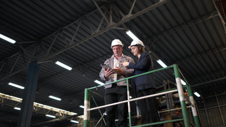 Business woman and warehouse workers are reviewing the list of items based on the documentationの写真素材