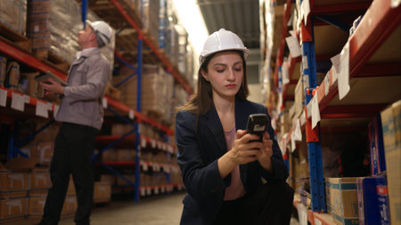Business woman and warehouse workers are reviewing the list of items based on the documentationの写真素材