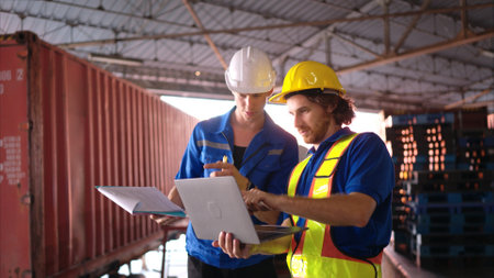 Warehouse workers are reviewing the list of items based on the documentationの写真素材