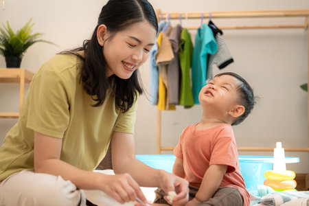 Little boy with breakfast with mom feeding him before bathingの写真素材