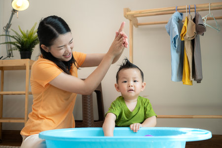 Mom and little child with taking a shower and dressing at home in the morningの写真素材