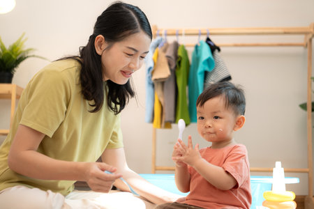Little boy with breakfast with mom feeding him before bathingの写真素材