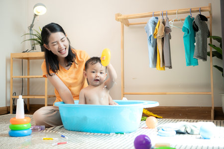 Mom and little child with taking a shower and dressing at home in the morningの写真素材