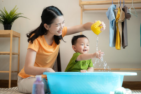 Mom and little child with taking a shower and dressing at home in the morningの写真素材