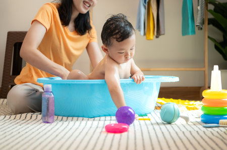 Mom and little child with taking a shower and dressing at home in the morningの写真素材