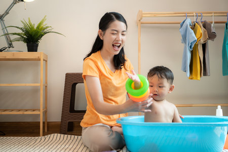 Mom and little child with taking a shower and dressing at home in the morningの写真素材