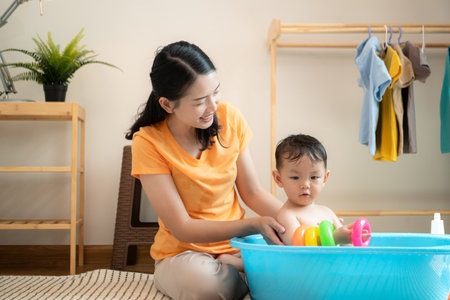 Mom and little child with taking a shower and dressing at home in the morningの写真素材