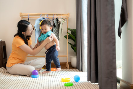 Mom and little child with taking a shower and dressing at home in the morningの写真素材