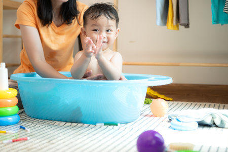 Mom and little child with taking a shower and dressing at home in the morningの写真素材