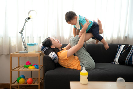 While in vacation at home, a mother engages in activities with little kidの写真素材