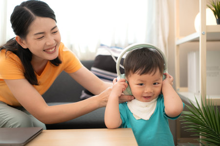 While in vacation at home, a mother engages in activities with little kidの写真素材