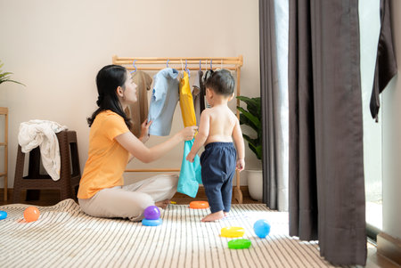 Mom and little child with dressing at home in the morningの写真素材