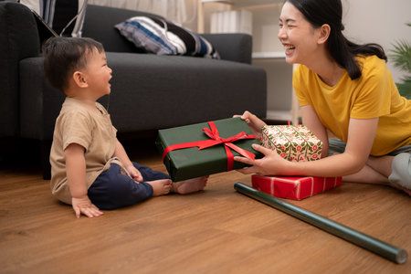 While in vacation at home, a mother gift wrap with little kidの写真素材