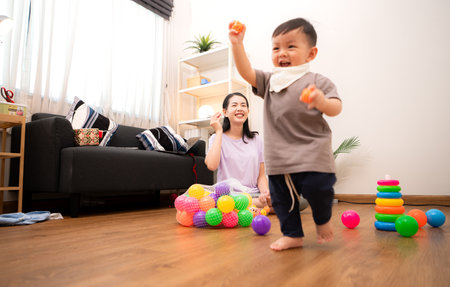 While in vacation at home, a mother engages in activities with little kidの写真素材