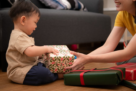 While in vacation at home, a mother gift wrap with little kidの写真素材