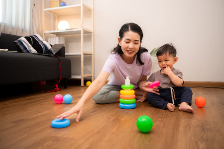 While in vacation at home, a mother engages in activities with little kidの写真素材