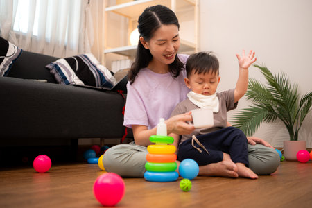 While in vacation at home, a mother engages in activities with little kidの写真素材