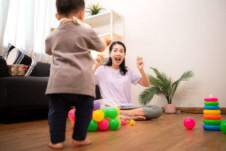 While in vacation at home, a mother engages in activities with little kidの写真素材