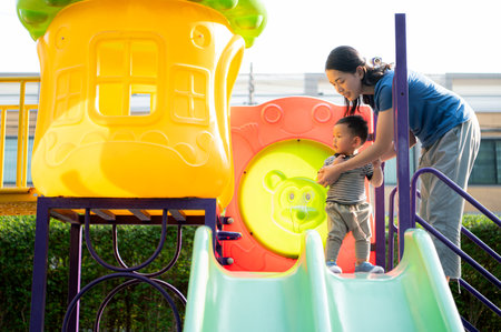 While in vacation at home, a mother engages in activities with little kid in the parkの写真素材