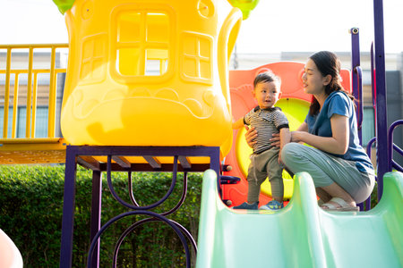 While in vacation at home, a mother engages in activities with little kid in the parkの写真素材