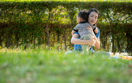While in vacation at home, a mother engages in activities with little kid in the parkの写真素材