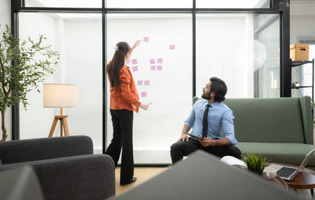 In a contemporary office, two young entrepreneurs are on a mission to generate ideas and establish a business projectの写真素材